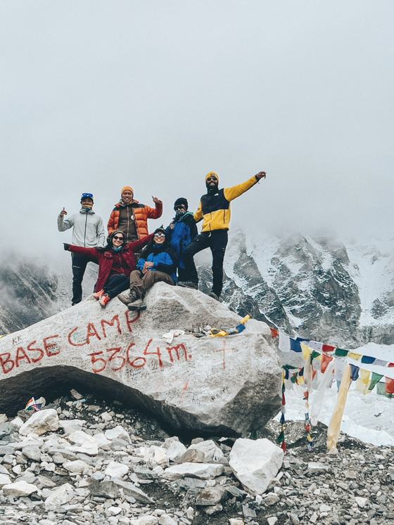 A group celebrating on the Everest Base Camp rock at 5,364 m