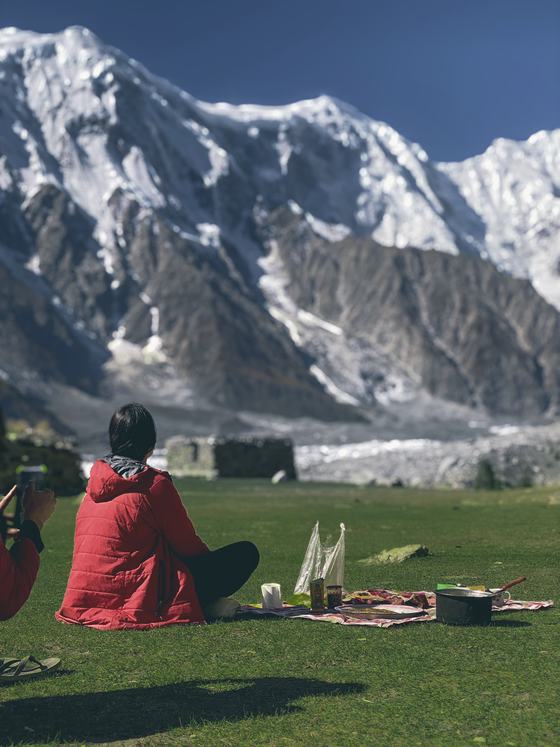 A picnic on a green meadow facing a huge snow face