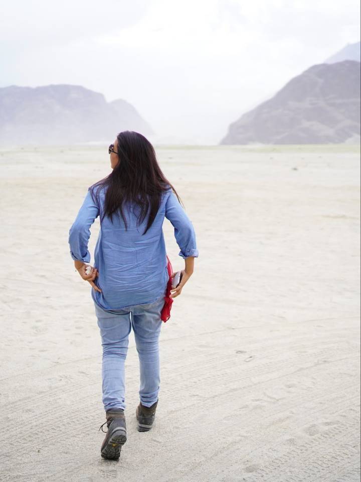 A traveller walking across the white sand of the Shigar cold desert