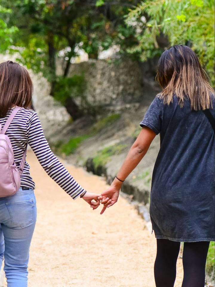 Two travellers holding hands on the path to Altit Fort